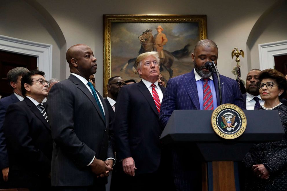 PHOTO: Donte Hickman, pastor at Southern Baptist Church in Baltimore, speaks as President Donald Trump and Sen. tim Scott, R-S.C., listen before Trump signs an executive order establishing the White House Opportunity and Revitalization Council.