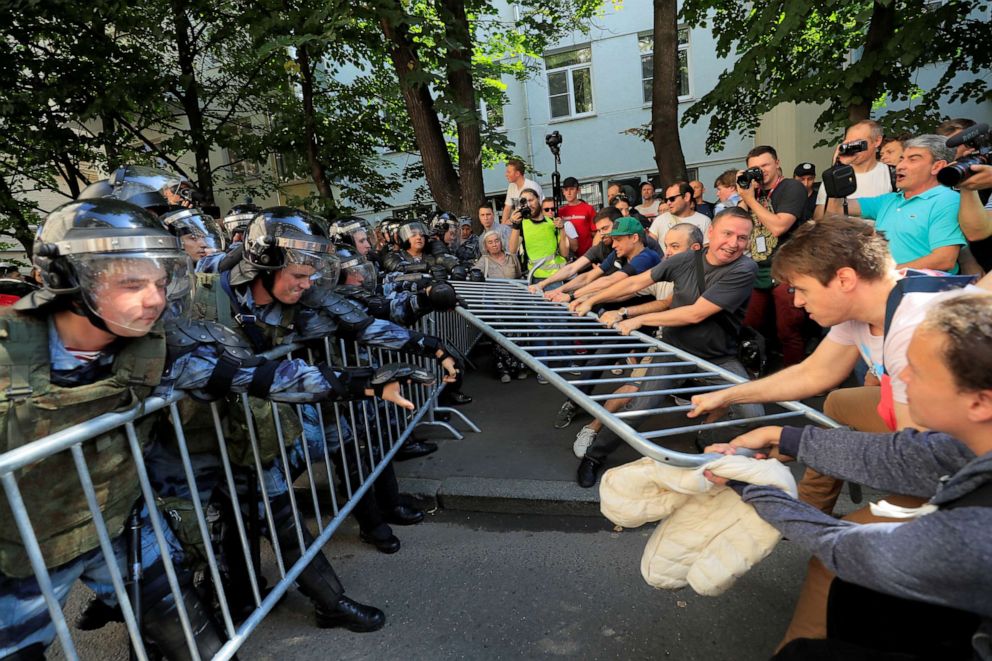 PHOTO:Demonstrators attempt to remove fences during a rally calling for opposition candidates to be registered for elections to Moscow City Duma, the capitals regional parliament, in Moscow, July 27, 2019. 