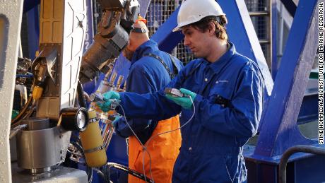 Researchers Andrey Volynkin and Justin Gwynn carefully inspect their underwater robot.