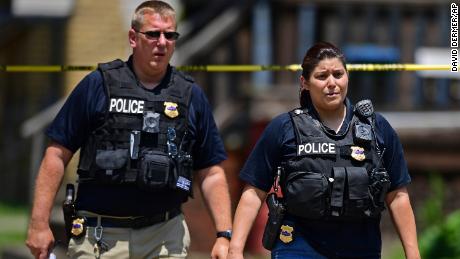 Officers on Tuesday work at the crime scene where several bodies were found.