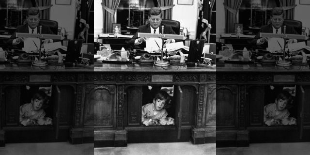 John F. Kennedy Jr. exploring his father's desk. — Getty