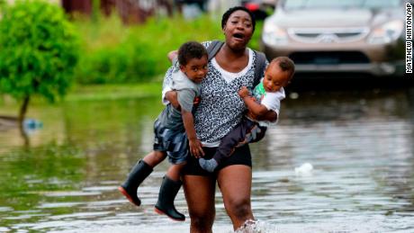 Terrian Jones reacts as she feels something moving in the water as she carries Drew and Chance Furlough to their mother Wednesday in New Orleans.
