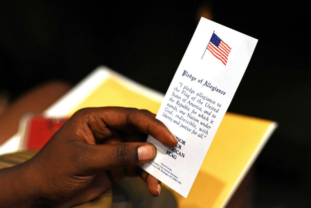 PHOTO: An immigrant holds a copy of the Pledge of Allegiance at her naturalization ceremony in San Antonio, Texas, June 13, 2019.