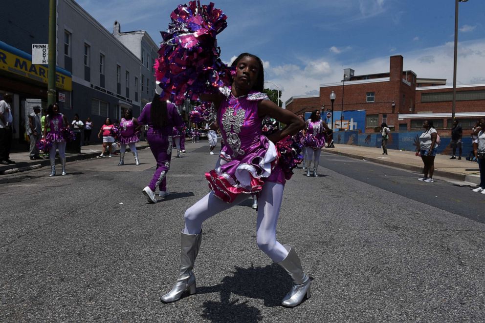 PHOTO: A cheerleader with a marching band participates in a parade on Pennsylvania Ave. in the Sandtown neighborhood in Baltimore, Maryland, U.S., June 8, 2019.