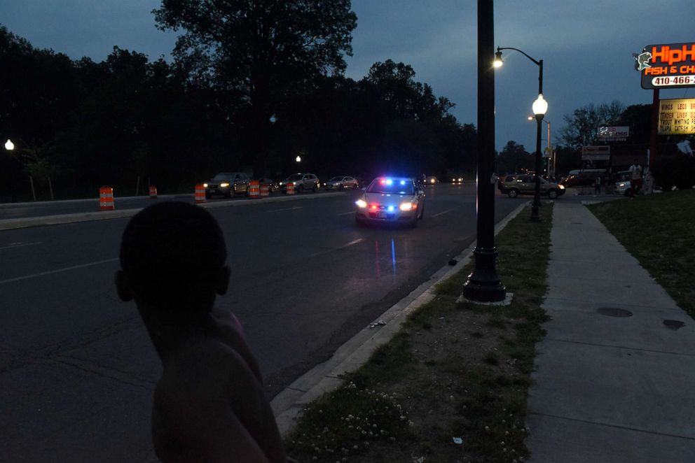 PHOTO: A young boy watches as a police car approaches while they gather in the parking lot of Hip Hop Chicken in Baltimore, Maryland, U.S., May 26, 2019.