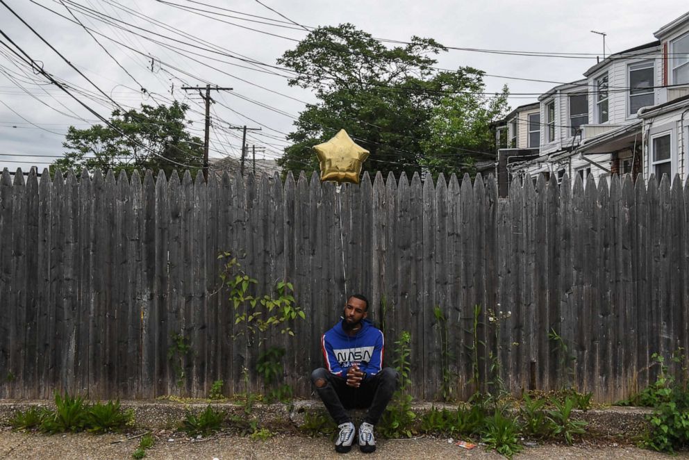 PHOTO: A man attending a memorial for George Phillips, who was a victim of gun homicide at the age of 19, holds a helium balloon in Baltimore, Maryland, May 11, 2019.