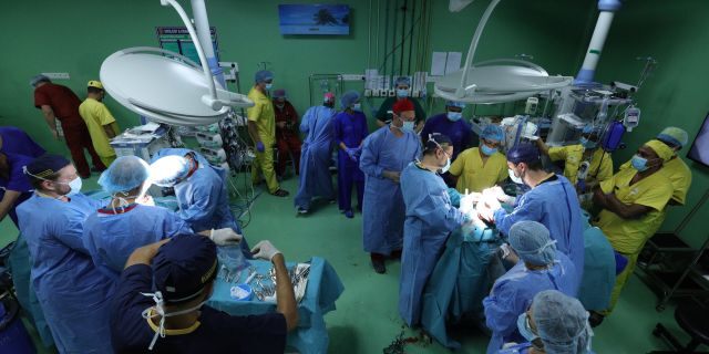 In this Aug. 1, 2019 photograph provided by Action for Defenceless People Foundation, Hungarian doctors Gergely Pataki, left, and Andras Csokay perform separation surgery on Rabeya and Rukaya. (Andras Taborosi/Action for Defenceless People Foundation via AP)