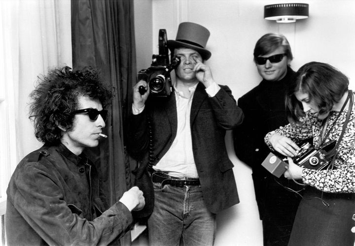 Pennebaker, holding a camera and wearing a top hat, with Bob Dylan.