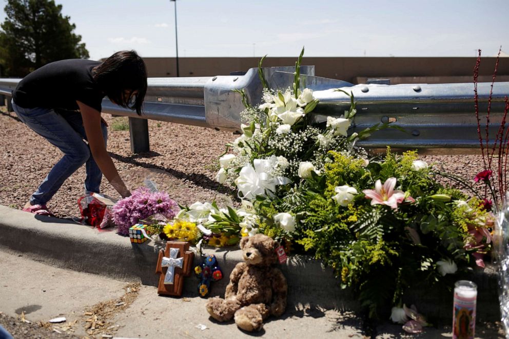 PHOTO: A woman places flowers at the site of a mass shooting at a Walmart in El Paso, Texas, Aug. 4, 2019.