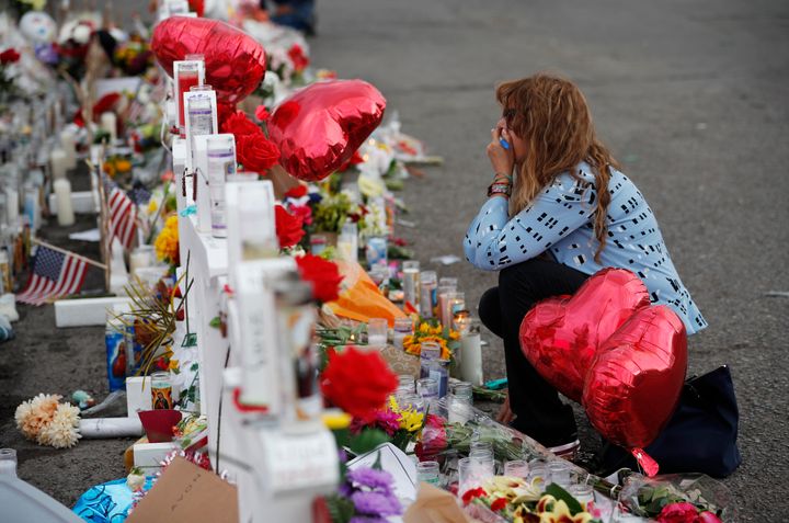 Gloria Garces kneels in front of crosses at a makeshift memorial near the scene of the mass shooting in El Paso, Texas.