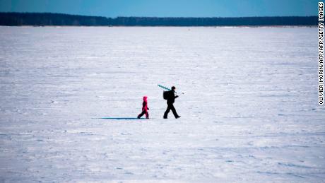 A man and his son go ice-fishing in Vaasa area, on the frozen Bothnia sea (Baltic Sea), on March 20, 2018, in Vaasa.