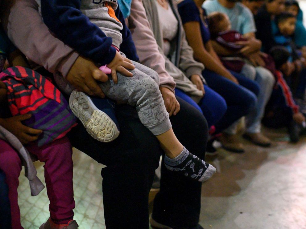 PHOTO: Recently detained migrants, many of them family units, sit and await processing in the US Border Patrol Central Processing Center in McAllen, Texas on August 12, 2019.