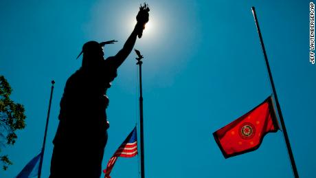 The flags of Oklahoma, the United States and the Cherokee Nation fly behind a sculpture of Lady Liberty at the Cherokee Capitol Square in Tahlequah.