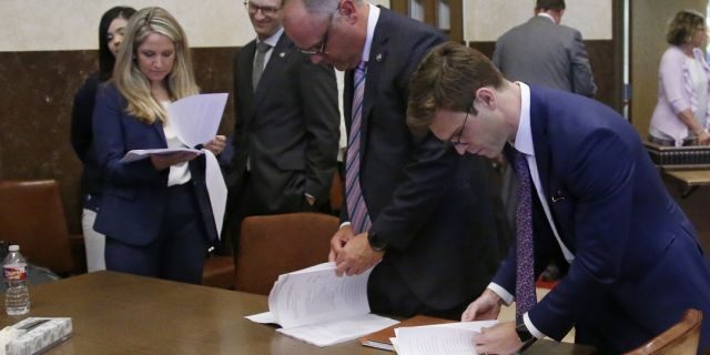 Attorneys for the state looking over court documents following Judge Thad Balkman's announcement of his decision. (AP Photo/Sue Ogrocki, Pool)