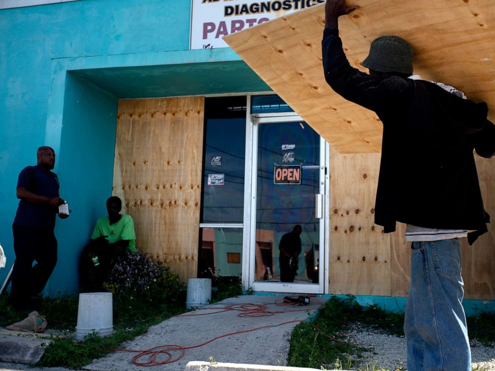 PHOTO: Workers board up a shop window front as they make preparations for the arrival of Hurricane Dorian, in Freeport, Bahamas, Friday, Aug. 30, 2019.