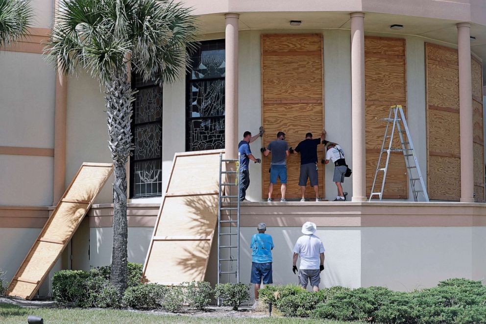 PHOTO: Workers cover stained glass windows with plywood sections at the Santa Maria del Mar Catholic Church in preparation for Hurricane Dorian, Aug. 30, 2019, in Flagler Beach, Fla.
