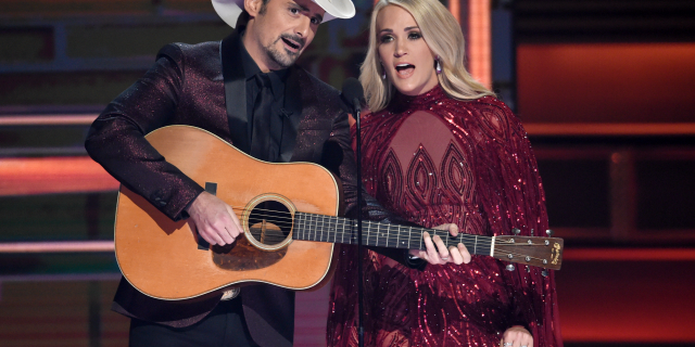 Hosts Brad Paisley, left, and Carrie Underwood during the opening of the 51st annual CMA Awards in Nashville, Tenn. Underwood will be working triple-duty at the 2018 Country Music Association Awards as co-host, performer and nominee. The singer, who is hosting the show alongside Brad Paisley for the 11th time, is pregnant and will hit the stage Wednesday night at the Bridgestone Arena in Nashville, Tennessee.