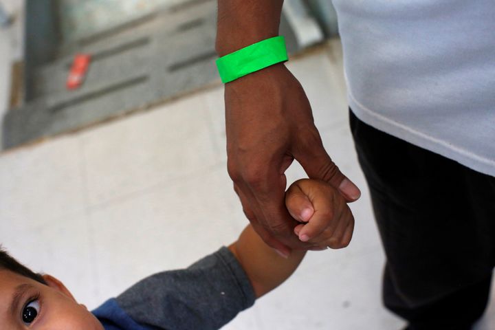 A child grabs the hand of his father at a Catholic shelter in Laredo, Texas, which gives temporary shelter to asylum-seekers 