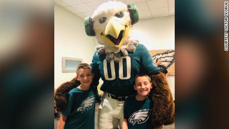 Twins Jack and Ryan Ykoruk, who have autism, play with Swoop, the Philadelphia Eagles mascot.