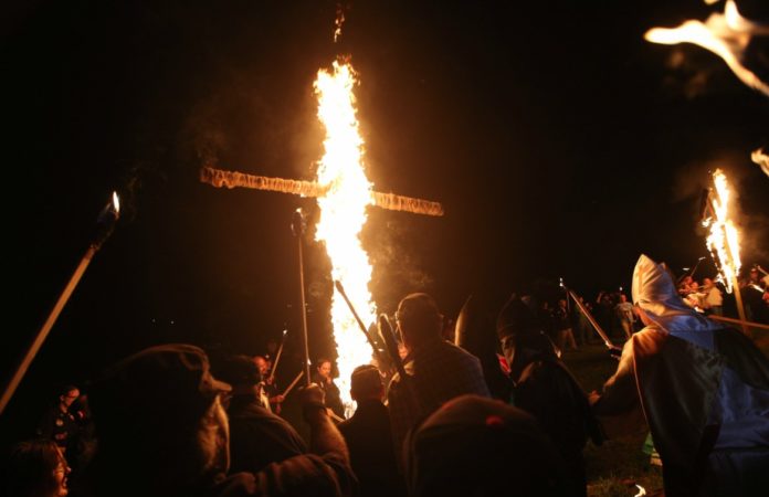 In this Saturday, April 23, 2016 photo, members of the Ku Klux Klan participate in cross burnings after a 