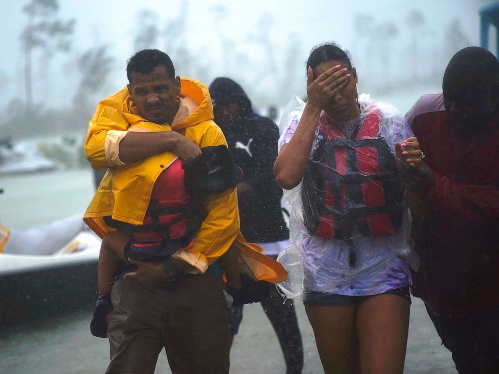PHOTO: A family is escorted to a safe zone after they were rescued as Hurricane Dorian continues to rain in Freeport, Bahamas, Sept. 3, 2019.