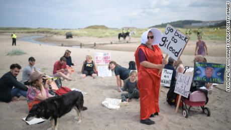 A woman wears a costume in the style of the &quot;Handmaid&#39;s Tale&quot; on a beach near Turnberry.