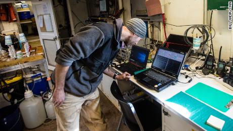 Ryan McCabe, on board a NOAA research vessel, examines data from the warming Arctic seas.
