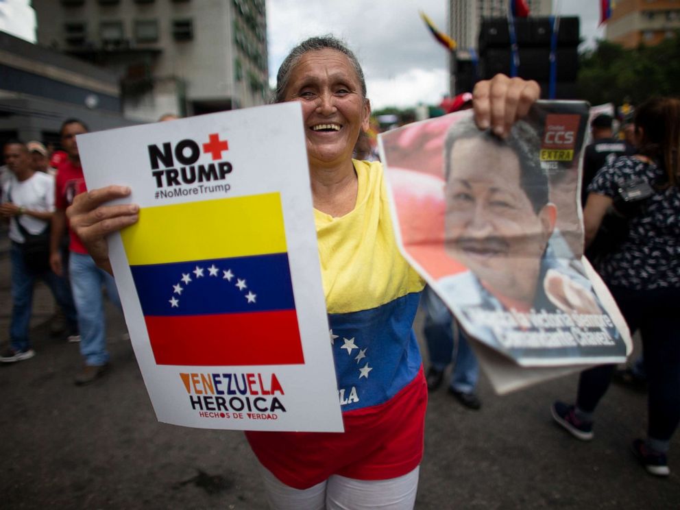 PHOTO: A supporter of President Nicolas Maduro holds a poster that in Spanish reads No more Trump and an image of Late President Hugo Chavez, during an anti-imperialist rally in Caracas, Venezuela, August 31, 2019.