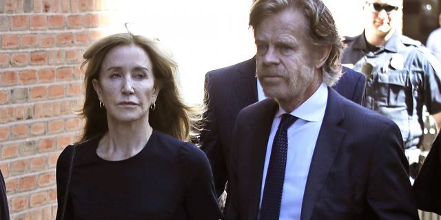 Felicity Huffman arrives at federal court with her husband William H. Macy for sentencing in a nationwide college admissions bribery scandal, Friday, Sept. 13, 2019, in Boston. (AP Photo/Elise Amendola)