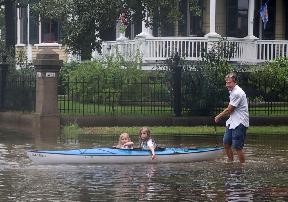PHOTO: Don Dressler pulls his granddaughters Elsie and Jillian Deans on a kayak through the water after the rain from Tropical Storm Imelda stopped in Galveston, Texas, on Sept. 18, 2019.