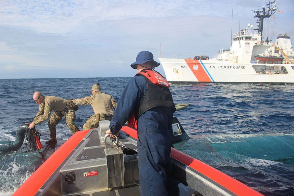 PHOTO: Members of a U.S. Coast Guard Cutter Valiant boarding team transfer narcotics between an interceptor boat and a suspected smuggling vessel in the Eastern Pacific in September 2019.