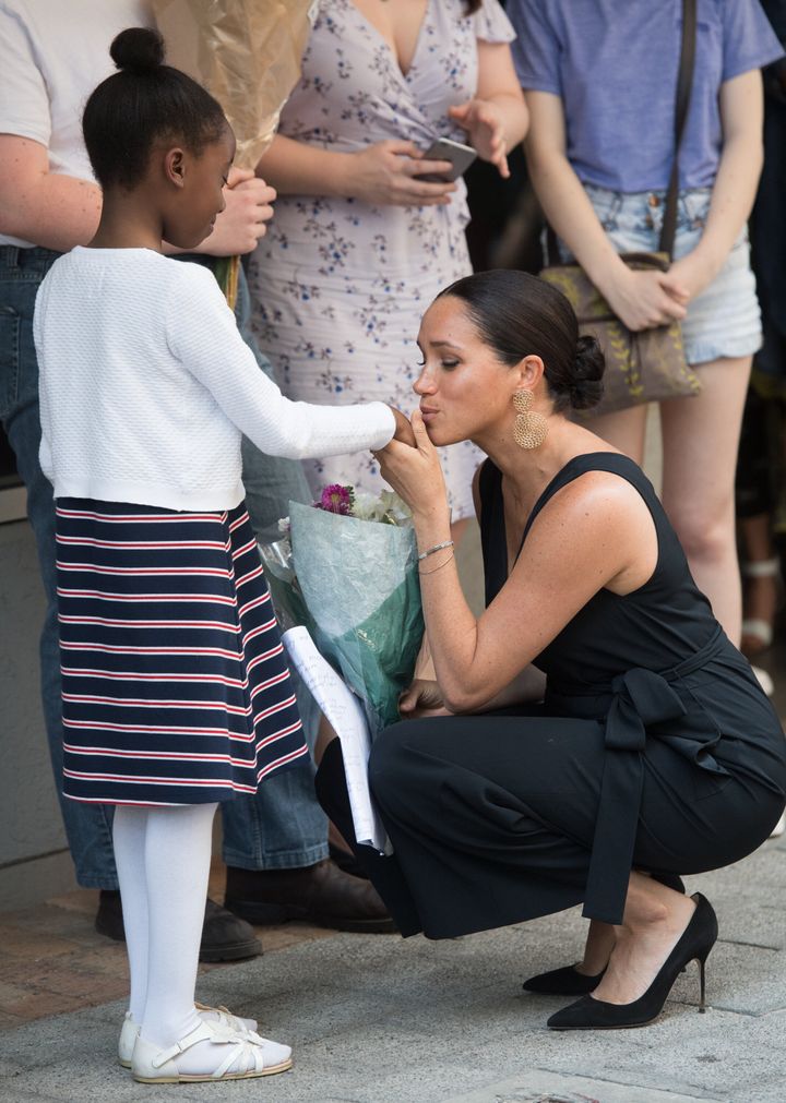 Meghan greeting a young girl at a mothers2mothers event.