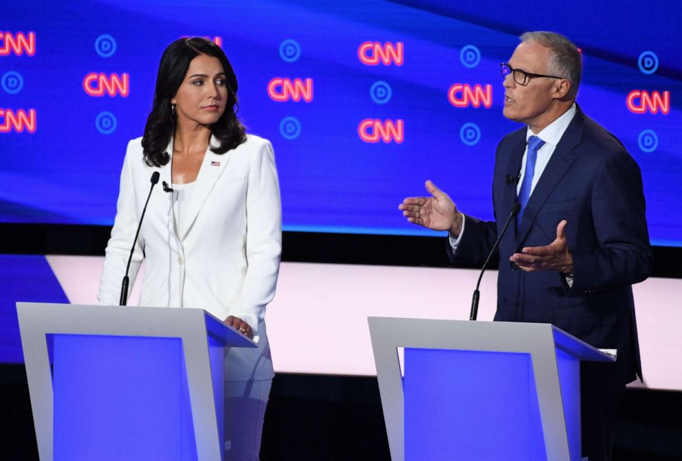 PHOTO: Democratic presidential hopefuls US Representative for Hawaiis 2nd congressional district Tulsi Gabbard (L) and Governor of Washington Jay Inslee (R) speak during the second round of the second Democratic primary debate.