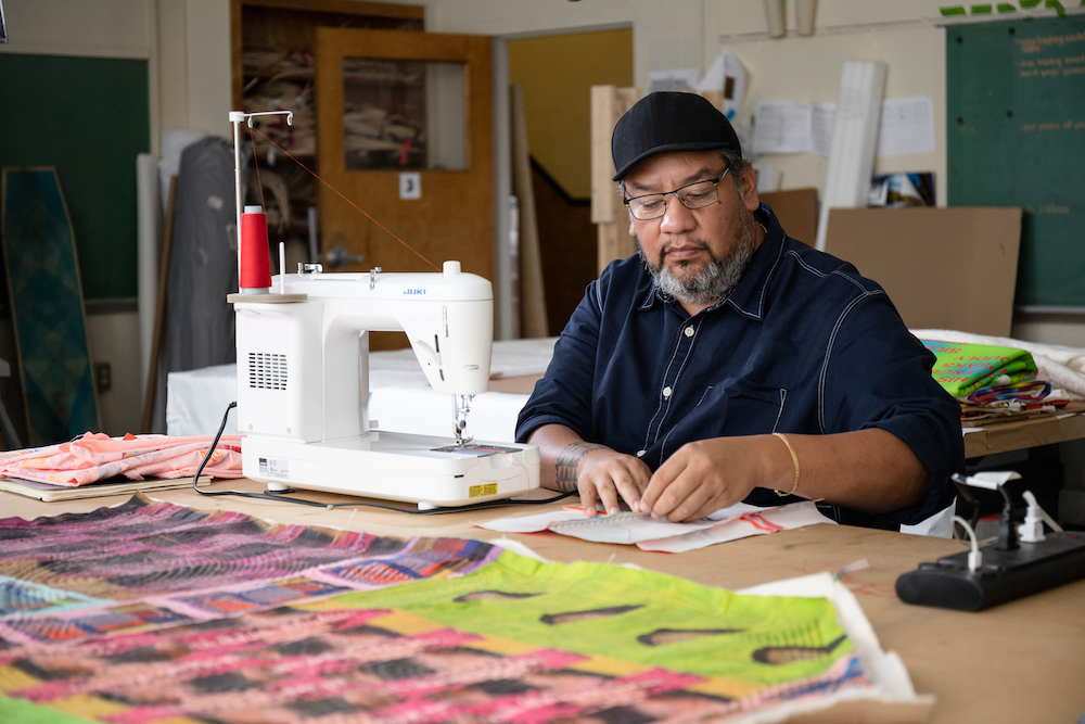 Jeffrey Gibson sewing in his studio.