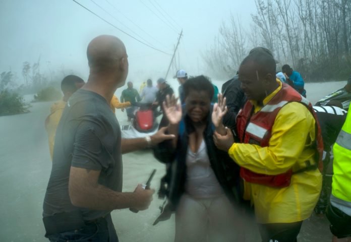 Volunteers rescue several families that arrived on small boats, from the rising waters of Hurricane Dorian, near the Causarina bridge in Freeport, Grand Bahama, Bahamas, Tuesday, Sept. 3, 2019. The storm’s punishing winds and muddy brown floodwaters devastated thousands of homes, crippled hospitals and trapped people in attics. (AP Photo/Ramon Espinosa) thegrio.com