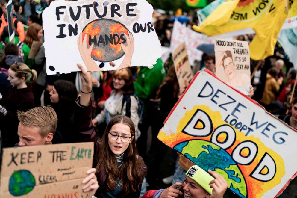 PHOTO: Protesters hold placards as they march during the Global Climate Strike organised by the Fridays For Future at the end of the global climate change week in The Hague, the Netherlands, on September 27, 2019.