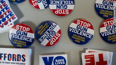 Pins and stickers advocating to stop gun violence are on display during the Gun Safety Town Hall on Monday, August 26 in Aurora, Colorado.