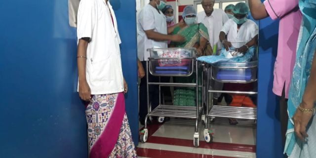 Hospital staff watch as proud dad Rajarao Mangayamma brings his new born twins to a press conference in India. 