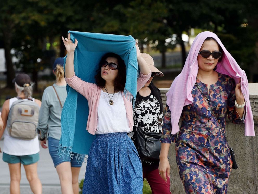 PHOTO: Tourists visiting the Lincoln Memorial shield themselves from the sun as temperatures are expected to soar into mid-90s (32C), on October 2, 2019, in Washington, DC.