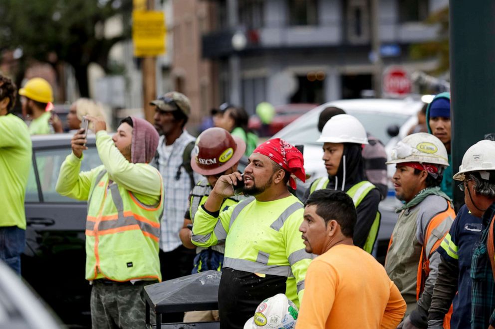 PHOTO: Construction workers look on after a large portion of a hotel under construction suddenly collapsed in New Orleans on Oct. 12, 2019.