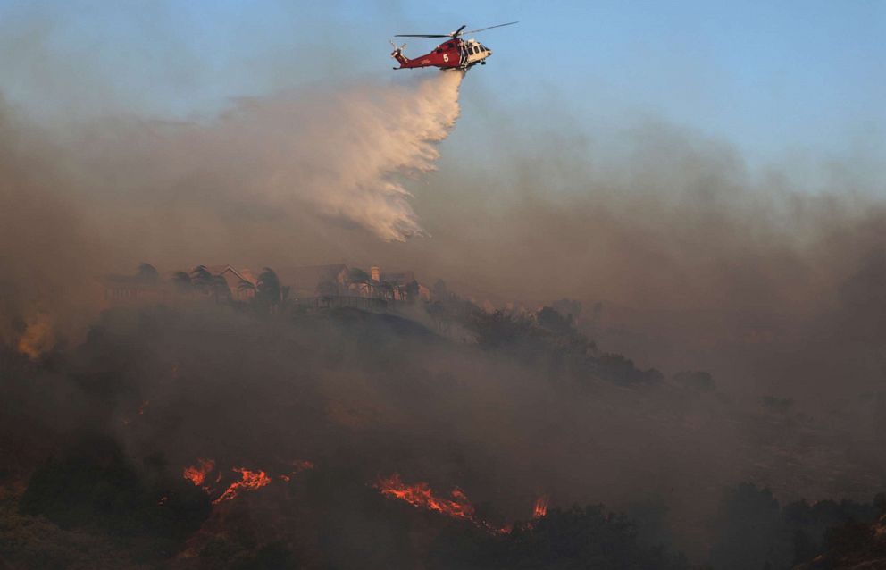 PHOTO: A firefighting helicopter works the Saddleridge Fire on Oct. 11, 2019, near Porter Ranch, Calif.