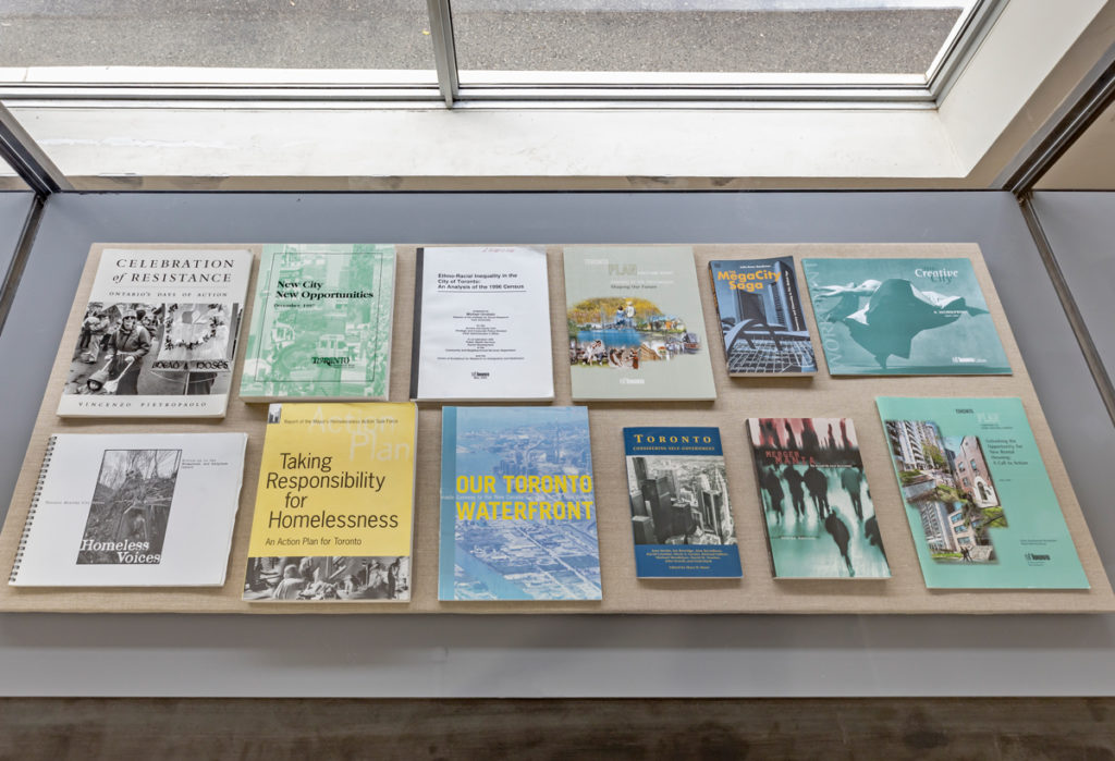 Luis Jacob's ;The View From Here (Library);, 2019, is a collection of printed materials, published since 1872, relating to Toronto, installation view, at the 2019 Toronto Biennial of Art.