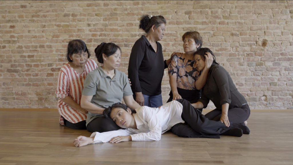 A still from Arin Rungjang's multi-channel video installation 'Ravisara', 2019, in which Thai immigrants to Berlin comfort each other briefly before leaving.