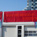 Outside the Biennial’s main venue, 259 Lake Shore Boulevard East, is a banner that reads “YOURS FOR INDIGENOUS SOVEREIGNTY” by the ReMatriate Collective, who are based in unceded and ancestral territories of the xʷməθkwəy̓əm, Skwxwú7mesh and Səl̓ílwətaʔ/Selilwitulh Nations in Canada. The phrase is taken from picket signs by a three-year protest against Muckamuck Restaurant that brought together indigenous women and other allied activists in 1978.