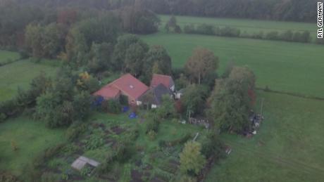 The farm is shielded by trees and appears to have a vegetable garden.