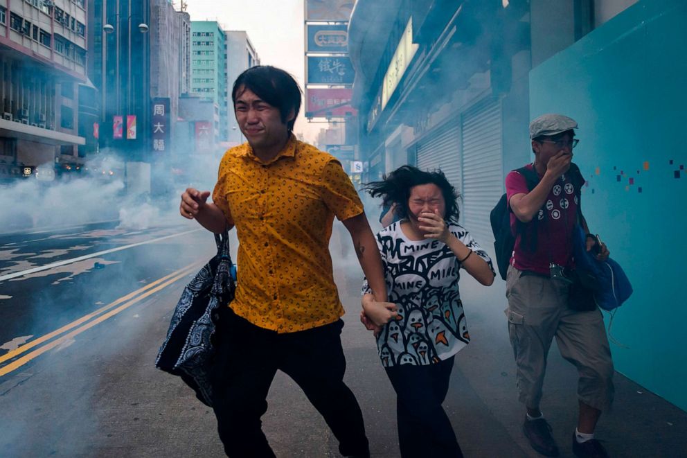 PHOTO: Bystanders along Nathan Road react from tear gas fired by police during a pro-democracy march in the Kowloon district in Hong Kong, Oct. 20, 2019. 