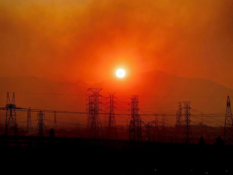 PHOTO: In this Oct. 11, 2019, file photo, smoke from the Saddle Ridge Fire hangs above power lines as the sun rises in Newhall, Calif.