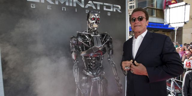 Cast member Arnold Schwarzenegger poses by a Terminator replica at the premiere of 'Terminator Genisys' in Hollywood, California June 28, 2015. 