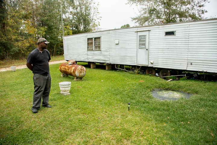 Community activist Aaron Thigpen examines raw waste pooling next to a mobile home in Lowndes County, Alabama.&nbsp;