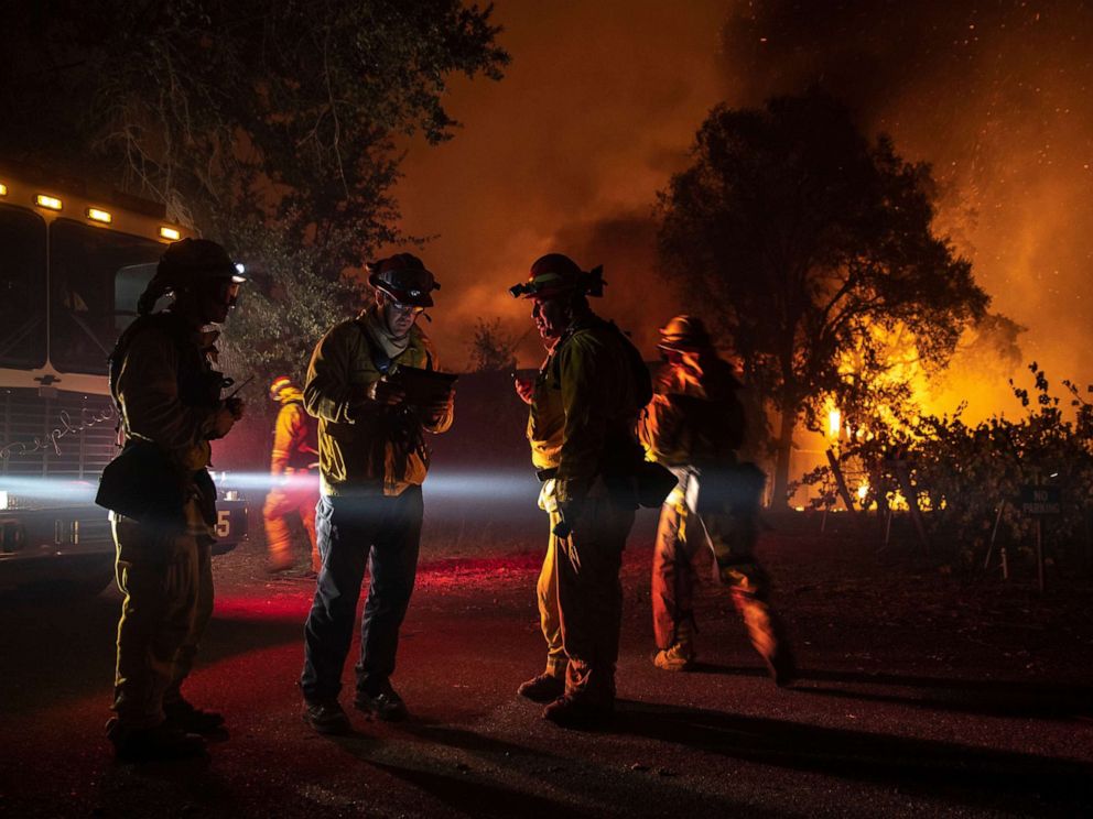 PHOTO: Firefighters plan their move as a building burns out of control, as the Kincade Fire continues to burn in Healdsburg, Calif., Oct. 27, 2019.